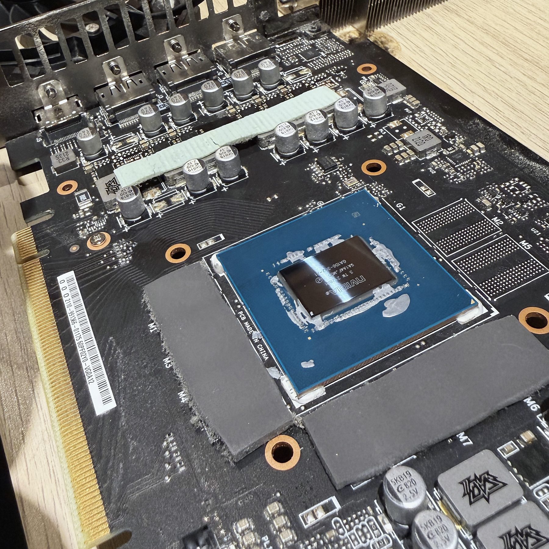 Graphics card with its cooler removed, chip exposed for fresh thermal paste