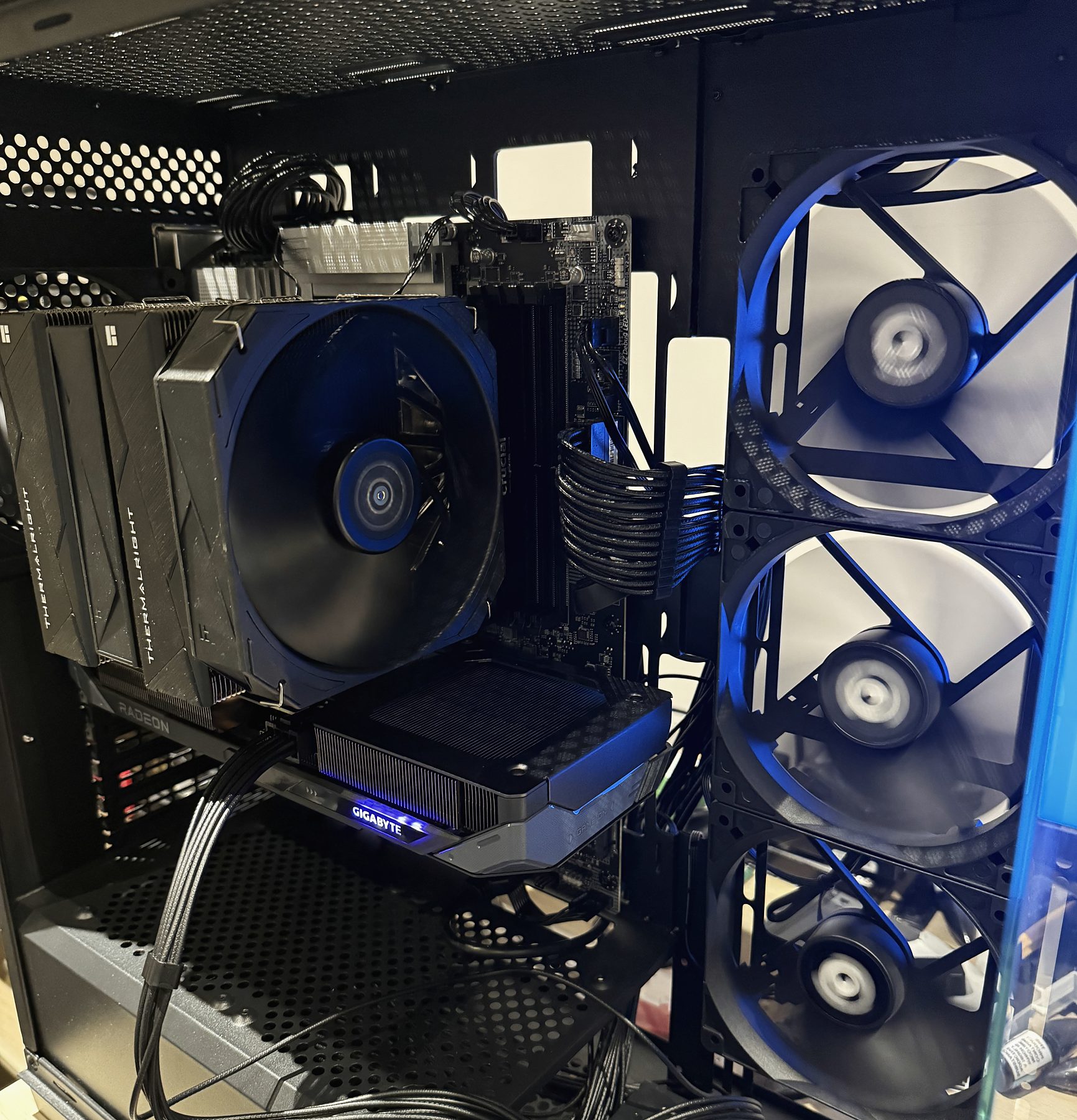 Inside a black PC build with blue-lit fans and a tower cooler